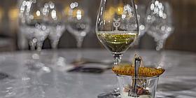 Ein Desertglas mit einem Weißwein dahinter