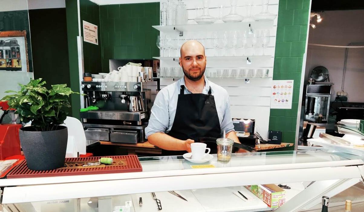 Daniel Pereira Ferreira Machado, der Inhaber des Austrogalo, steht hinter der Theke und hat gerade einen Kaffee zubereitet