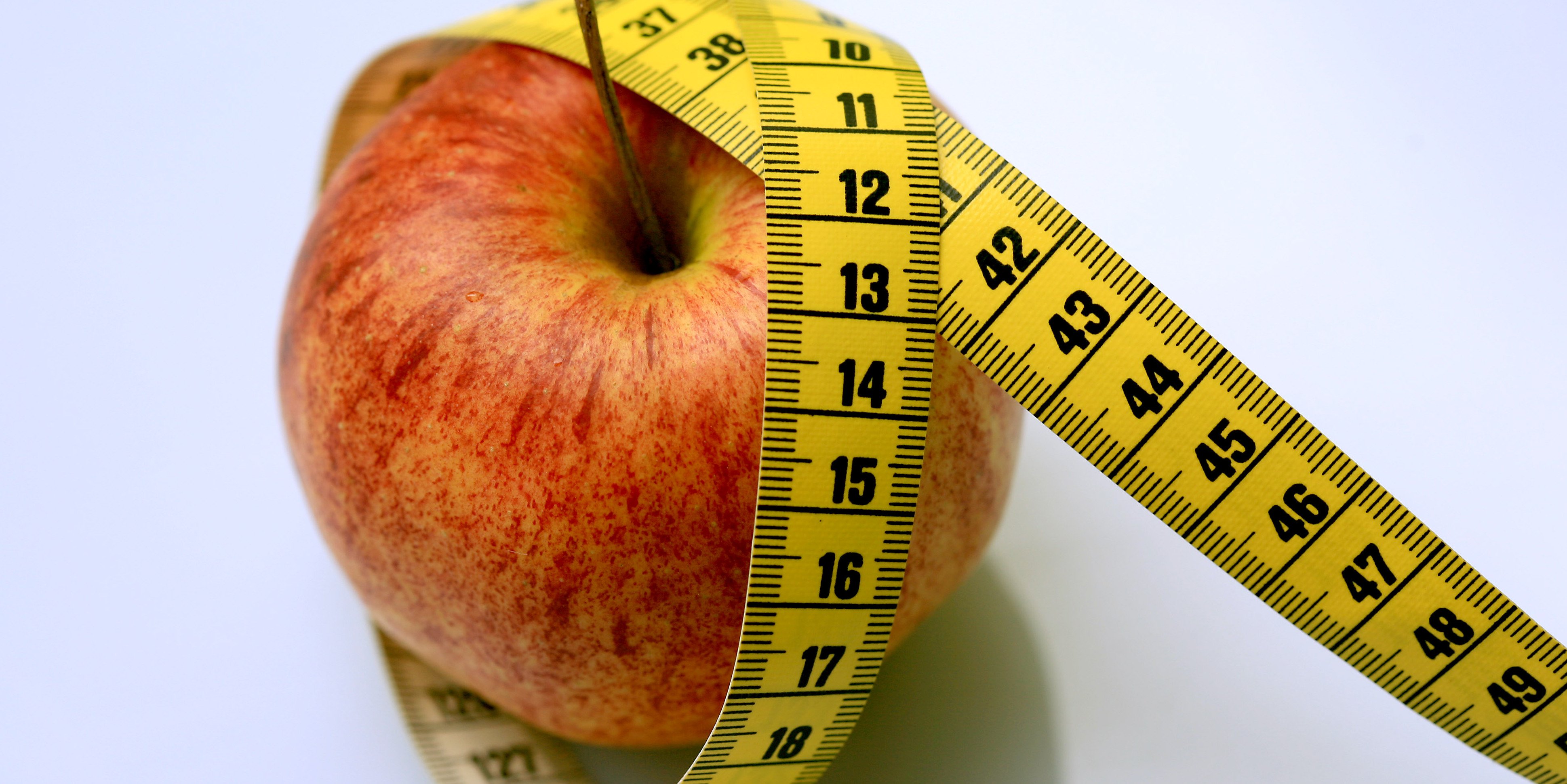 Apfel in Messband eingehüllt als Imagebild für Essstörungen