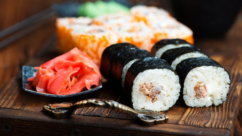 Buntes Sushi auf dunkler Holzplatte
