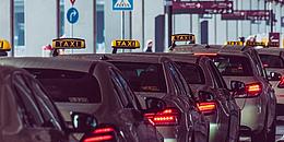 Mehrere Taxis stehen geparkt in einer Reihe am Wiener Flughafen