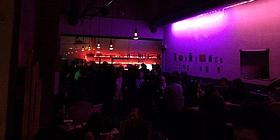 Die Schikaneder Bar, lila beleuchtet, mit vielen Menschen
