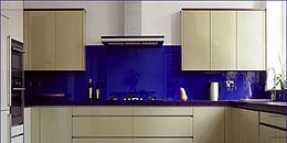 Blau lackierte Glas-Küchenrückwand in einer Küche mit weißen Frontseiten
