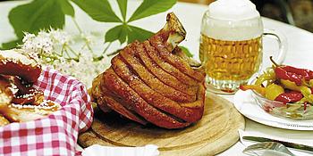 Stelze, Beilagen und Bier auf einem Tisch im Schweizerhaus im Wiener Prater
