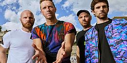 Foto der Band Coldplay, blauer Himmel im Hintergrund