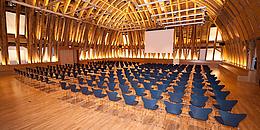 Ein großer Saal mit Parkettboden und einer Holzkuppel