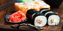 Buntes Sushi auf dunkler Holzplatte