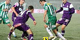 Spieler in violetten und in grünweißen Trikots kämpfen um den Ball