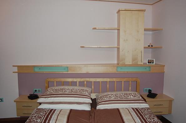 Schlafzimmereinrichtung aus hellem Holz mit Kopfteil, Nachtkästchen, Wandregale