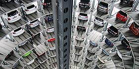 Zu sehen ist ein Parkturm, auf dem viele, viele Neuwagen übereinander geparkt stehen.