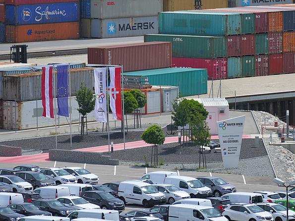 Die Flaggen Österreichs, der EU, des Hafen Wiens und der Stadt Wien wehen im Wind am Parkplatz des Hafen Wiens. 