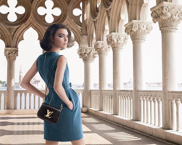Werbekampagne für Louis Vuitton mit einem Modell in einem petrolfarbenen Kleid in einem Arkadengang