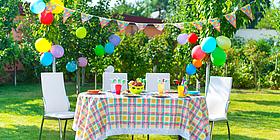 Ein Tisch im Freien mit bunter Dekoration und Luftballons