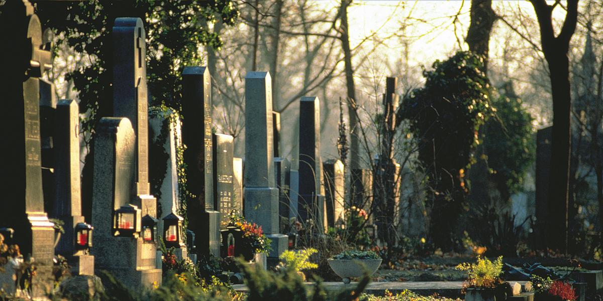 Friedhof mit vielen Grabsteinen und Grablichtern.