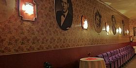 An der Wand hängen die Bilder vieler Filmlegenden, davor Kinosessel und kleine Tische mit Blumengestecken.