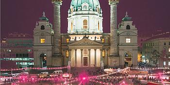 Karlskirche Wien beleuchtet mit buntem Christkindlmarkt am Karlsplatz 
