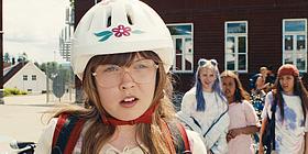 Mädchen mit großer Brille und Fahrradhelm, im Hintergrund ihre Mitschülerinnen