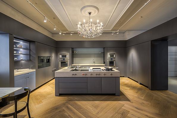 Moderne Designer Küche in grau mit Gaggenau Geräten eingerichtet und Luster