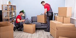 Zwei Männer packen Möbel ein und Entrümplen eine Wohnung