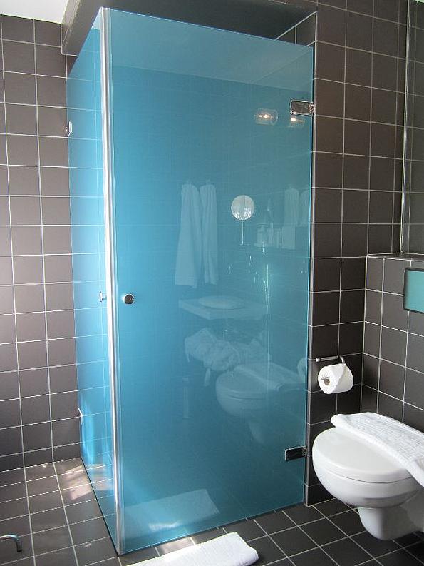L-förmige Verglasung einer Dusche in hellem Blau