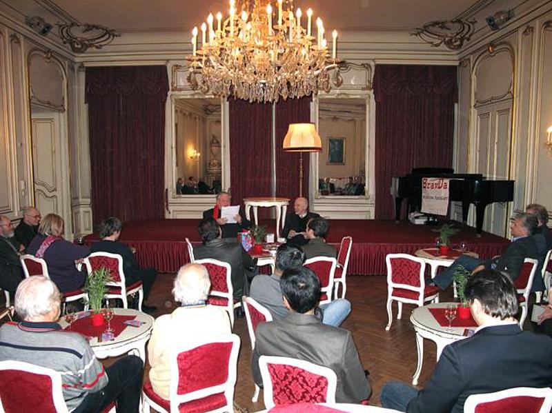 Ein Raum mit Personen, sitzend auf Stühlen