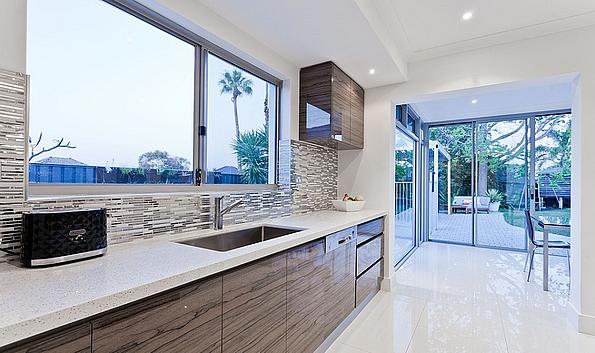 Moderne weiße Küche mit Metallrückwand