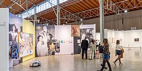 Besucherinnen und Besucher vor Leinwänden mit Kunst in der Marx Halle