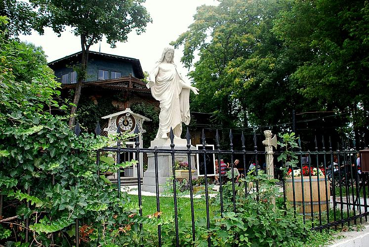 Christus Statue im Garten vor dem Schloss Concordia schräg vond er Seite über den Gusseisenzaun hinweg zu sehen
