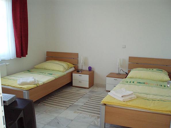 Zwei Einzelbetten mit gelber Bettwäsche