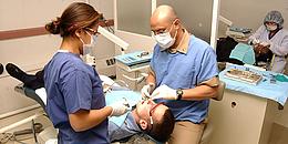 Zahnarzt und Assistentin behandeln Patienten