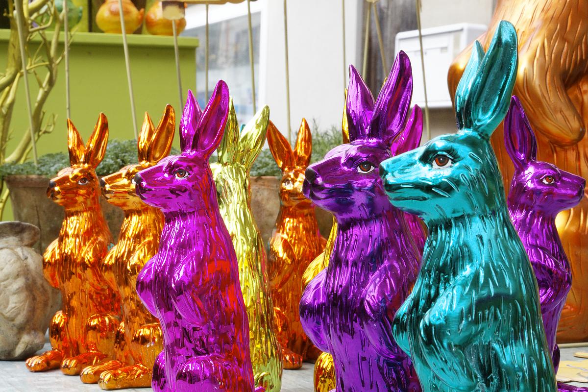 Osterhasenfiguren aus Metall in grellen Farben als Deko für das Osterfest