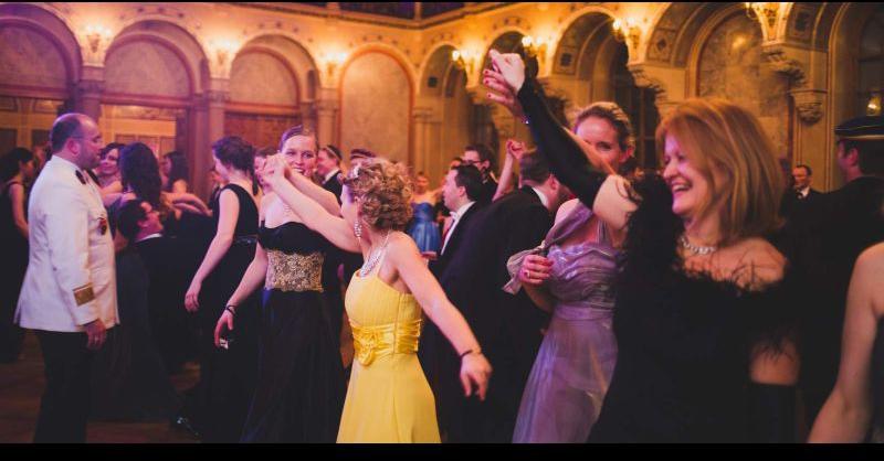 Tanzende Gesellschaft, im Vordergrund Frau im gelben Kleid
