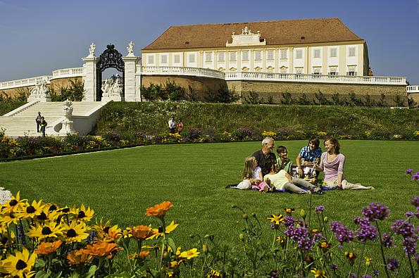 Picknickende Familie im Gras auf der fünften Terrasse von Schlosshof 