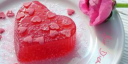 Rotes Herz und rosa Rose auf einem weißen Teller mit dem rosaroten Schriftzug "Für dich" darauf 