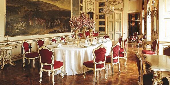 Gedeckter Tisch im reich verzierten Rössl-Zimmer, an der Wand hängt ein Gemälde, das eine Jagdszene zeigt.