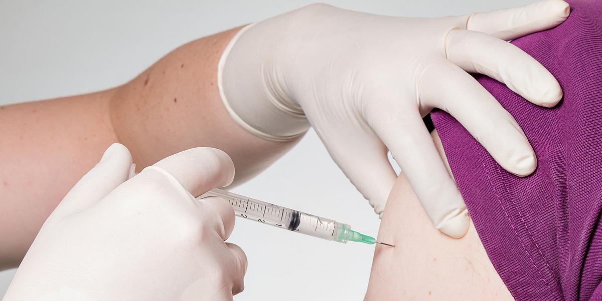 Patient bekommt eine Impfung per Spritze in den Oberarm