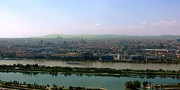 Weitwinkel auf die Donau, mit der Neuen Donau, Donauinsel, Wien Skyline und im Hintergrund den Wienerwald.