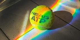 Tennisball, der von einem Regenbogen beleuchtet wird