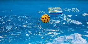 Ball und Surfbrett treiben im Pool