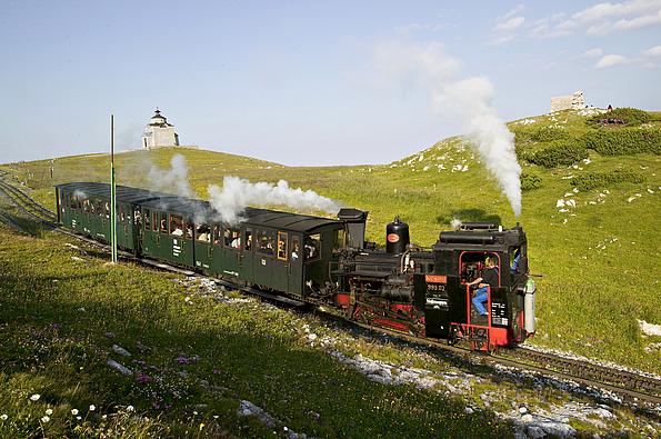 Dampfende Lok transportiert Passagiere auf den Schneeberg