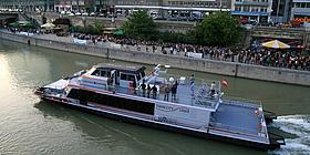 Ein Twin City Liner fährt gerade entlang des Donaukanals in Wien.