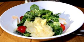 Kartoffelsalat in weißer Schüssel mit Garnie