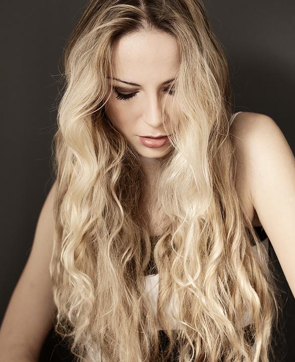 Frau mit langen blonden gewellten Haaren