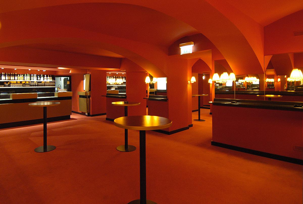 Bar im Kabarett Simpl besteht aus einem Raum ganz in Rot mit goldenen Stehtischen