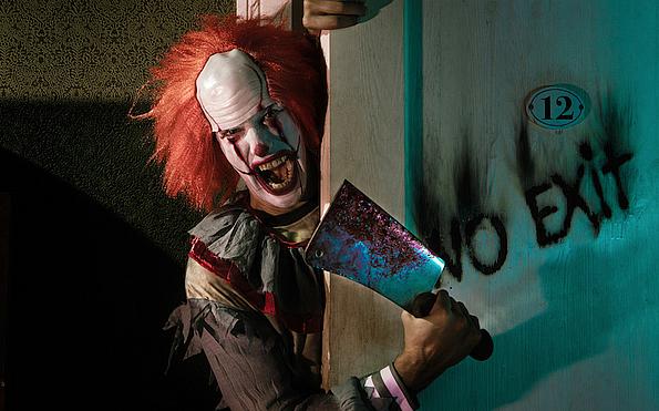 Clown lugt hinter Tür hervor mit blutigem Messer in der Hand, Schriftzug "No Exit"