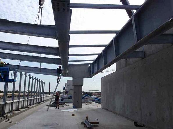 Gleisbauarbeitien U2 Verlängerung für die Seestadt Aspern: Stahltresen, die künftig das Dach der U-Bahnstation tragen sollen und zwei Arbeiter, einer auf einer Leiter.