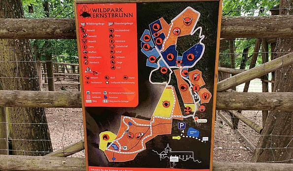 Der Plan des Wildparks hängt an einem Holzzaun
