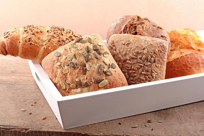 Brot und Gebäck in einer weißen Schüssel auf Holz