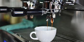Kaffeemaschine brüht Kaffee, weiße Kaffeetasse