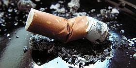 Ausgedämpfte Zigarette in einem schwarzen Aschenbecher